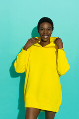 Happy black woman in oversized yellow hoodie