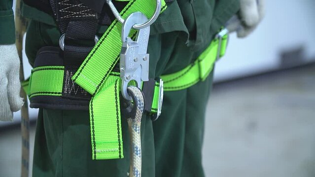 Working at height equipment. Fall arrestor device for worker with hooks for safety body harness on selective focus. Worker as a background.