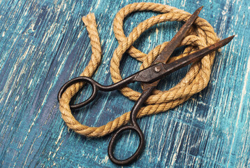 old vintage scissors and a rope on a blue old table.