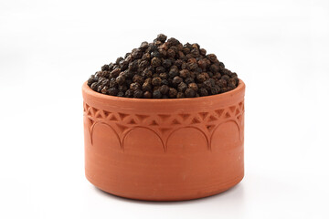 Indian spices Pepper powder with pepper corn in a terracotta bowl