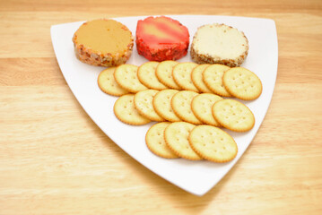 Cheddar Cheese Log Slices on a Plate with Round Crackers