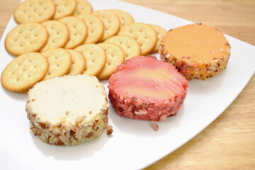 Cheddar Cheese Log Slices on a Plate with Round Crackers