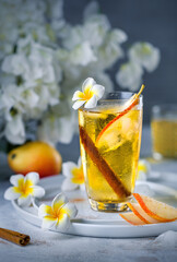 Pear lemonade with cinnamon. Summer refreshing cocktail. Fruit iced tea on a background with white flowers. Pear juice.