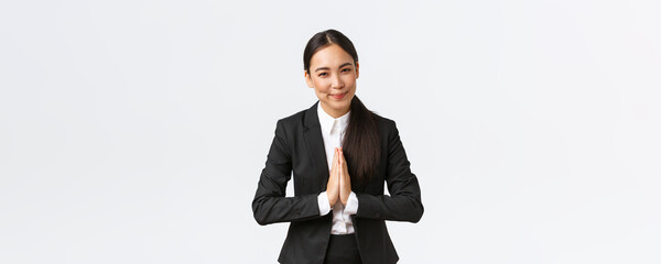 Friendly asian businesswoman hold hands together and bowing at business partners, greeting clients....
