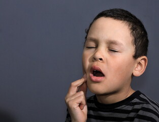 boy with toothache in pain on grey background stock photo