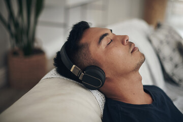 When my headphones are in, the world is blocked out. Shot of a young man using headphones at home.