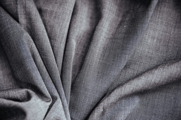 Fototapeta premium Gray wrinkled draped fabric. Sewing material is on the table.
