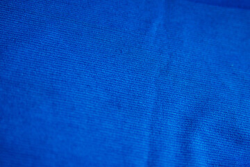 Blue wrinkled draped fabric. Sewing material is on the table.