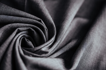 Gray wrinkled draped fabric. Sewing material is on the table.