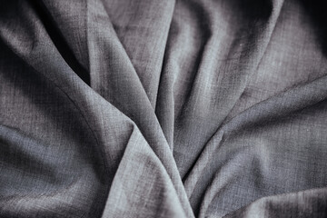 Obraz premium Gray wrinkled draped fabric. Sewing material is on the table.