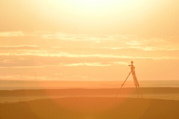 video camera on a tripod in the steppe at dawn
