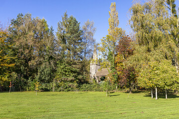 Fototapeta na wymiar Autumn colours at the church of St John the Baptist in the Forest of Dean village of Huntley, Gloucestershire, England UK
