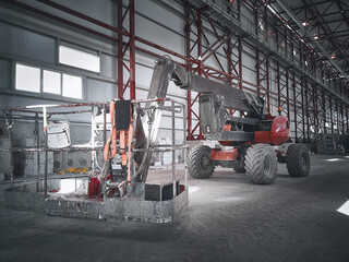 Articulated telescopic elevator. Basket of boom lift picker inside industrial building. Man lifting hydraulic platform parked. Red telehandler at construction site © Philipp Berezhnoy