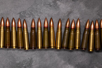 Bullets on gray background. Cartridges 7.62 caliber for Kalashnikov assault rifle. Top view, flat lay