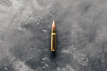 Bullet on gray background. Cartridge 7.62 caliber for Kalashnikov assault rifle - obrazy, fototapety, plakaty