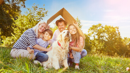 Familie mit zwei Kindern und Hund bei Hausbau Konzept