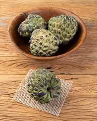 Sugar apples or custard apples in a bowl over wooden table