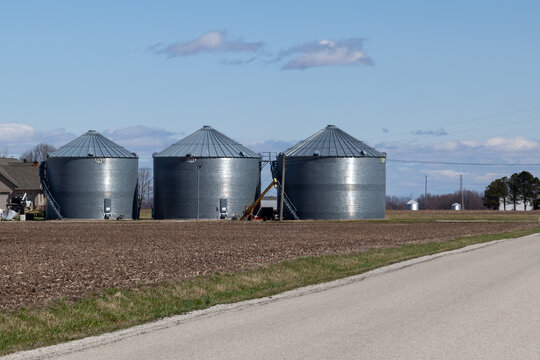 Illinois, USA - March 26, 2022: GSI storage grain bins are seen in the farm in Illinois, USA. GSI is an American manufacturer of steel farm bins, storage grain bins, grain silos and more.