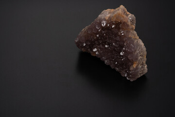 amethyst stone. Close-up of purple amethyst mineral rock on the black background. High angle view. Copy space for text