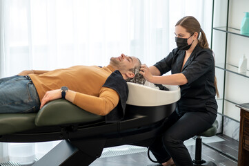 Beautician massaging head to the male customer