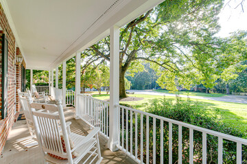 Southern country living covered front porch summer spring day tree sunlight warm sunshine white...