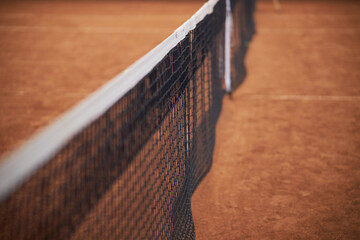 net on clay tennis court, soft focus. Tennis net with bokeh sand in the background. soft focus