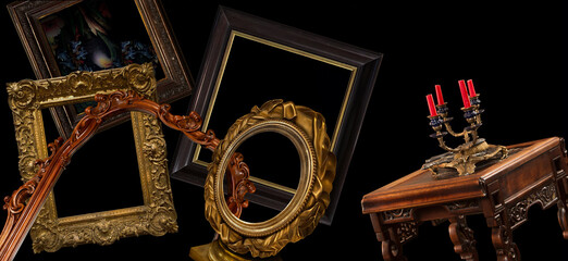 Antique still life with old ancient carved frames and ancient carved table with a candlestick isolated on black