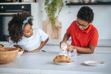 Obraz na płótnie Canvas Two kids in the kitchen having breakfast