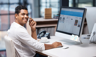 Taking care of your inquiries with speed. Portrait of a young businessman working on a computer in a call centre.