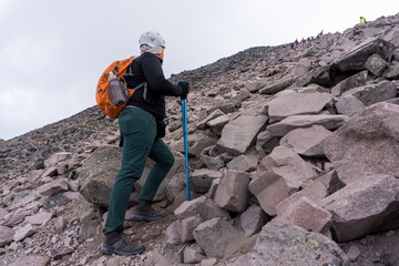 Tourist hiker with a backpack walking on mountain path