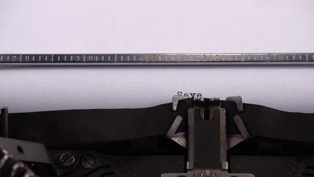 Typing phrase Save Ukraine ! on retro typewriter.