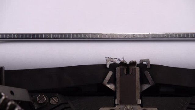 Typing word Ukrainian on retro typewriter.