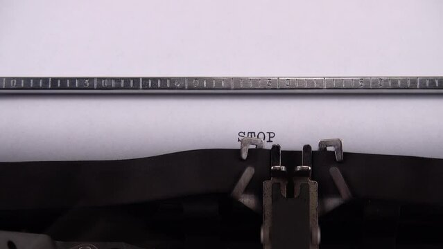Typing phrase STOP WAR ! on retro typewriter.