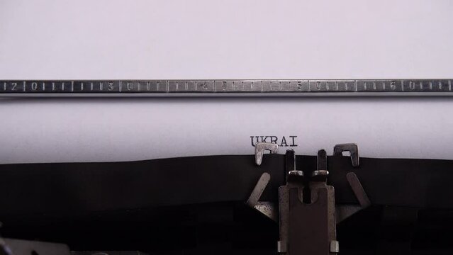 Typing European country name Ukraine on retro typewriter.