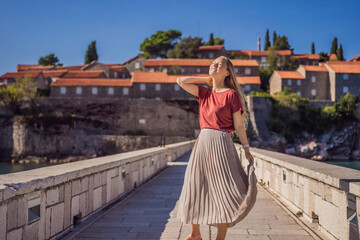 Fototapeta na wymiar Woman tourist on background of beautiful view of the island of St. Stephen, Sveti Stefan on the Budva Riviera, Budva, Montenegro. Travel to Montenegro concept