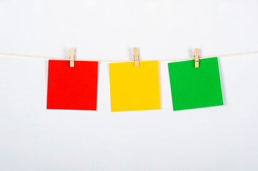 Tres post its con colores de semáforo de rojo a verde, colgados para ejercicio, estrategia o trabajo en equipo, conceptos a tratar.