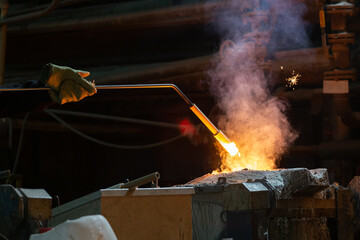 hand of foundry worker measuring temperature of molten steel with ceramic probe