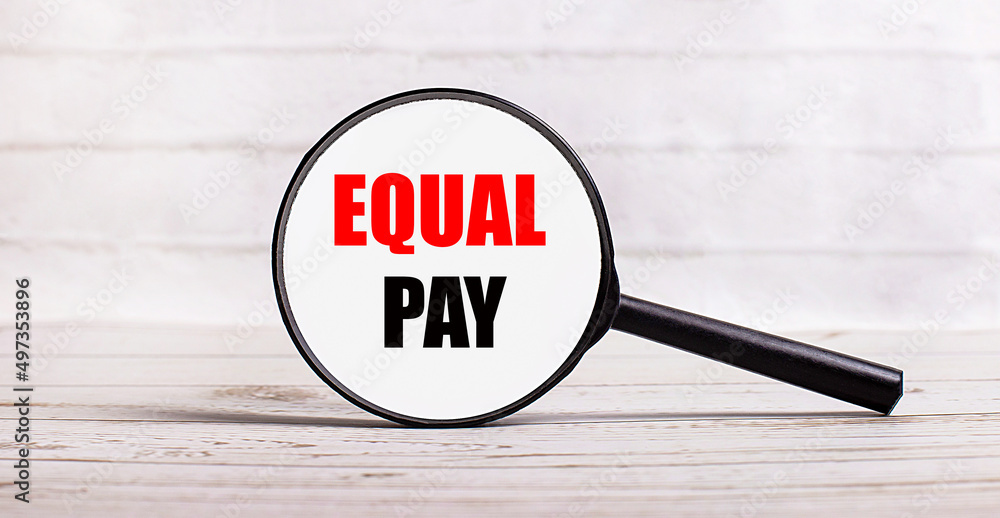 Poster the magnifying glass stands vertically on a light background with the text equal pay