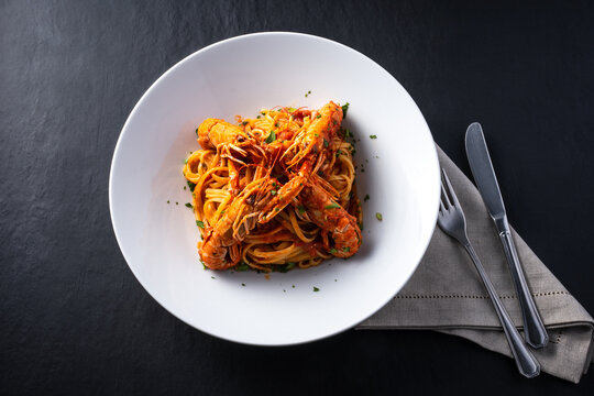 top view plate of shrimp busara spaghetti on dark background