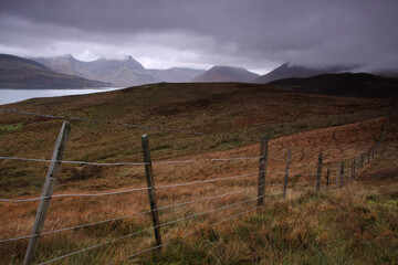 Distant view of Cuillin Hills over moor on a cloudy Isle of Skye in Scottish Highlands