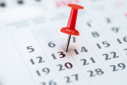Red push pin on calendar 13th day of the month, mark the Event day with a Pin. Pin on calendar day thirteen, date number 13. Thirteenth day of the month is marked with a red thumbtack