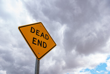 dead end sign with clouds