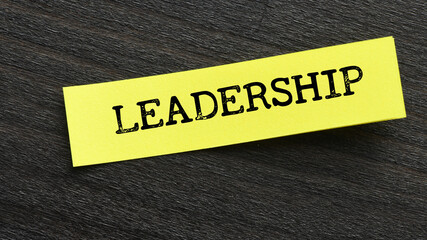 The word LEADERSHIP on a yellow piece of paper and a black background.