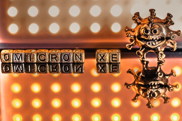 XE. A new variant of SARS-CoV-2 coronavirus. Omicron sub variant. Viral gold color on a black...