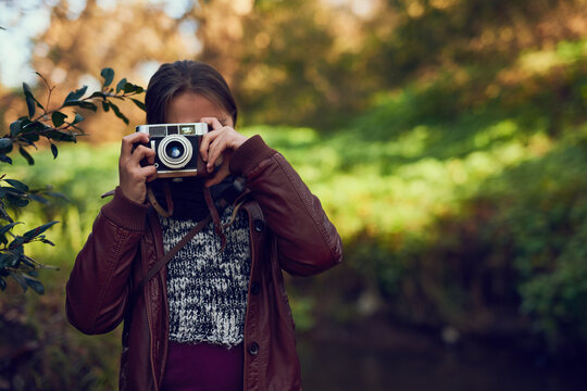 Its like seeing the world through new eyes. Shot of a young girl taking pictures with a vintage camera outdoors.