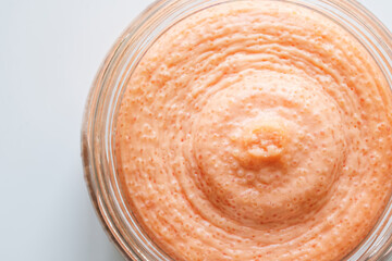 Pollack fish caviar, in a white creamy sauce, in an open glass jar. Macro. White background. View from above