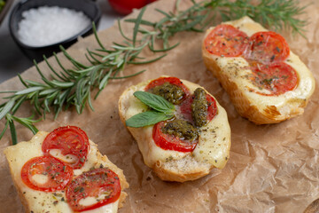 Bruschetta with tomatoes, mozzarella cheese and basil on a cutting board. Traditional italian appetizer or snack, antipasto