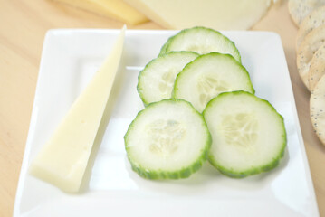 Burpless Cucumber Slices and Cheese on a White Plate	