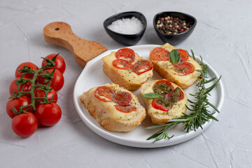Italian bruschetta with roasted tomatoes, mozzarella cheese and herbs 
