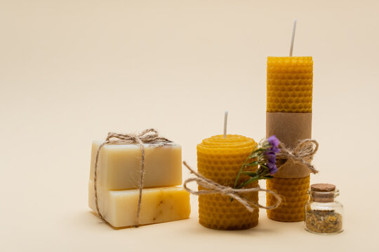 Craft soap near candles on beige background.
